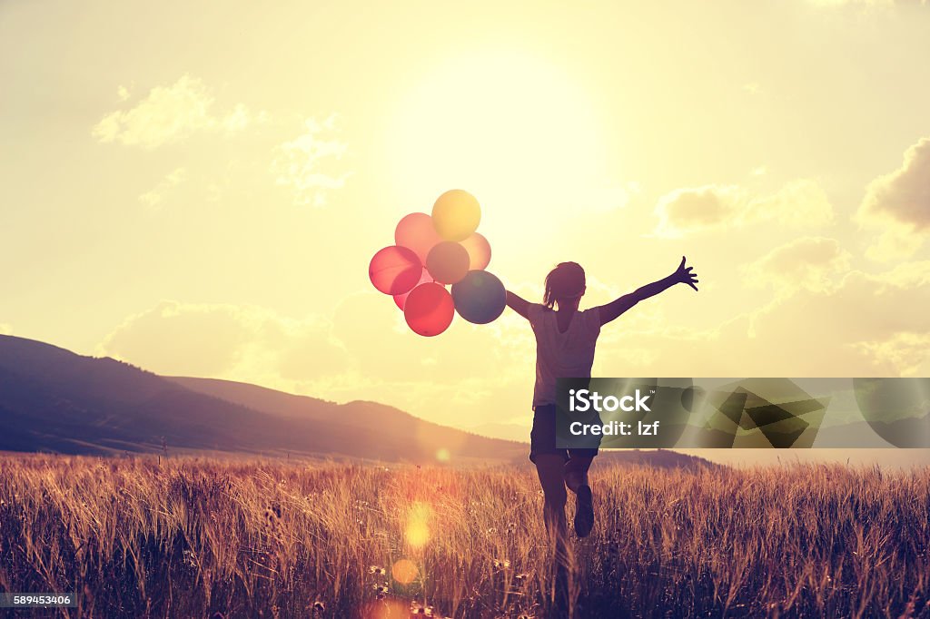 cheering young asian woman on grassland with colored balloons Balloon Stock Photo