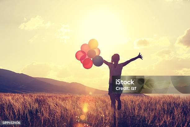 Cheering Young Asian Woman On Grassland With Colored Balloons Stock Photo - Download Image Now
