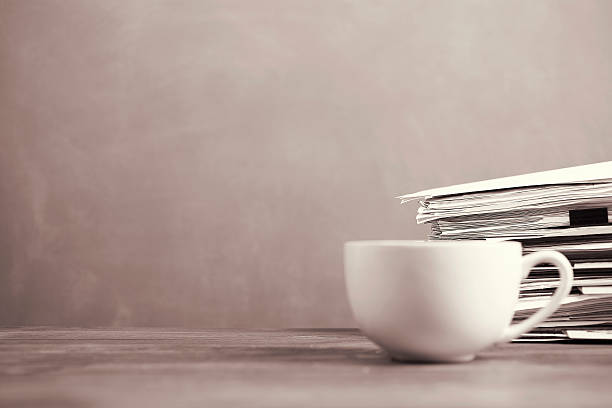 istock Coffee mug, papers stacked on teachers school desk with chalkboard. 589453454