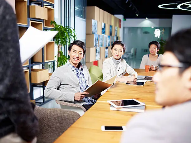 Photo of young asian entrepreneurs meeting in office