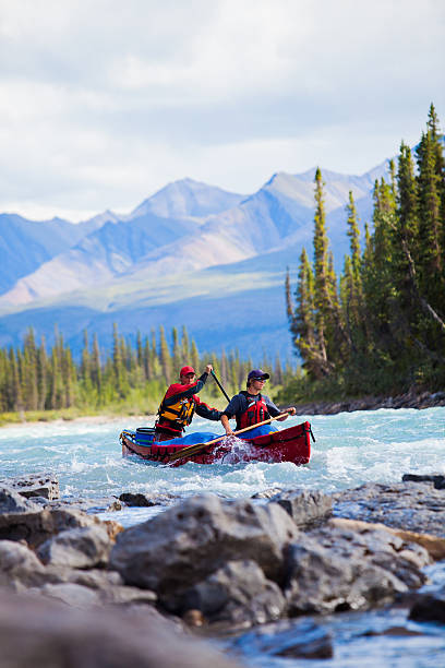 istock Two young men paddle a river in Northern Canada 589454758