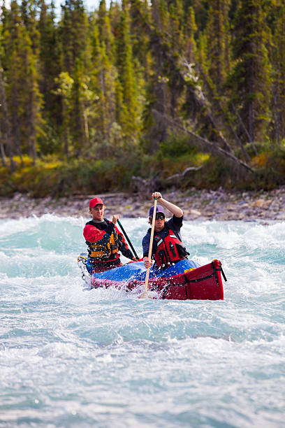istock Two young men paddle a river in Northern Canada 589455048