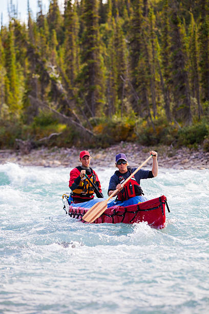 istock Two young men paddle a river in Northern Canada 589455148