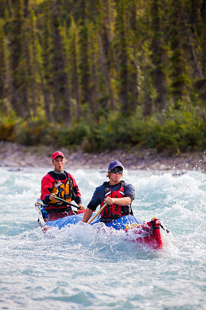 istock Two young men paddle a river in Northern Canada 589455264