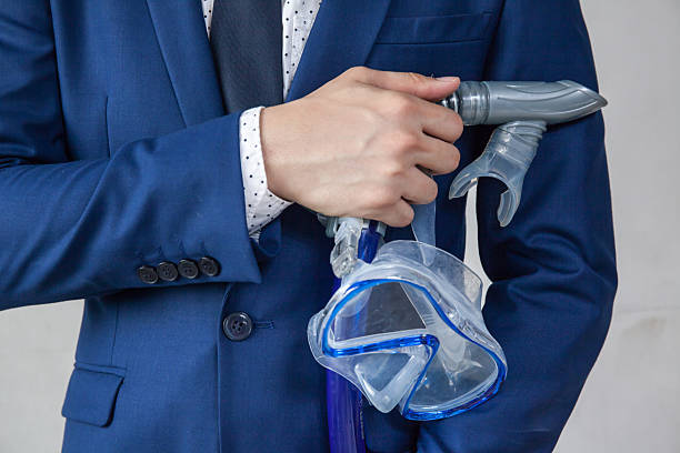 istock Businessman holding snorkeling goggle in white background 589456868