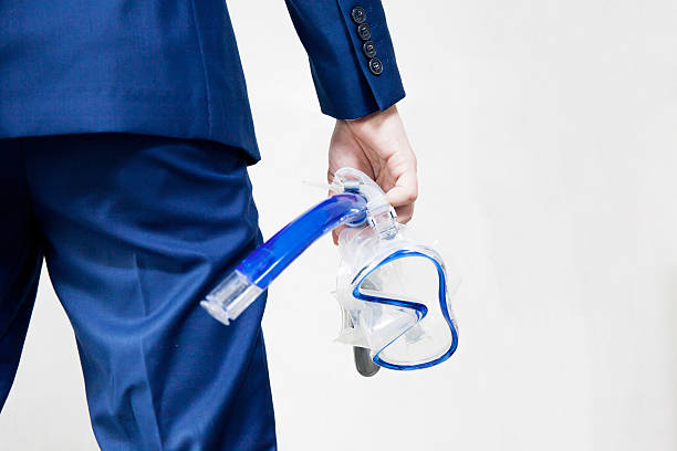 Businessman holding snorkeling goggle in white background - busi