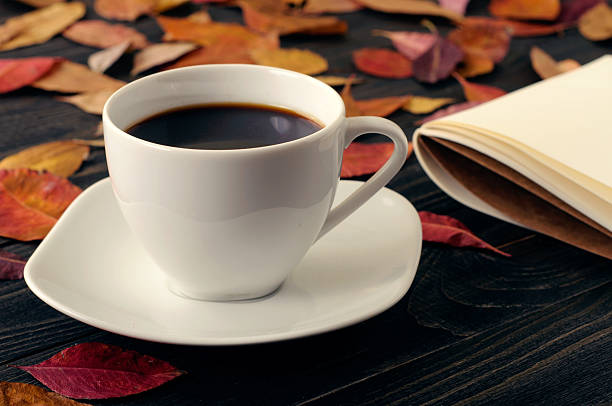 istock Cup coffee on wooden table with autumn dry leaves 589459204
