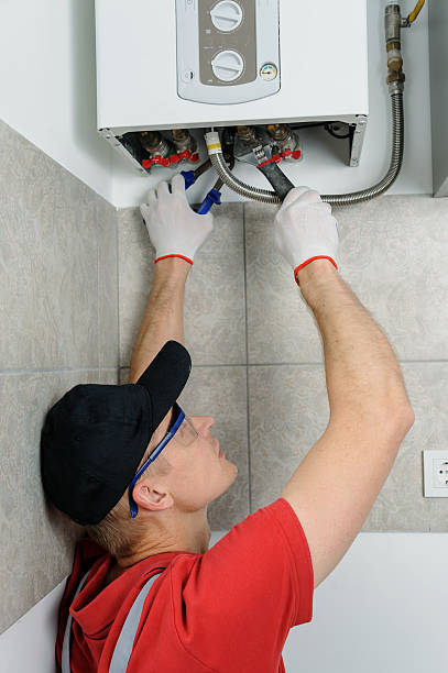 istock Plumber attaches to pipe gas boiler. 589459580