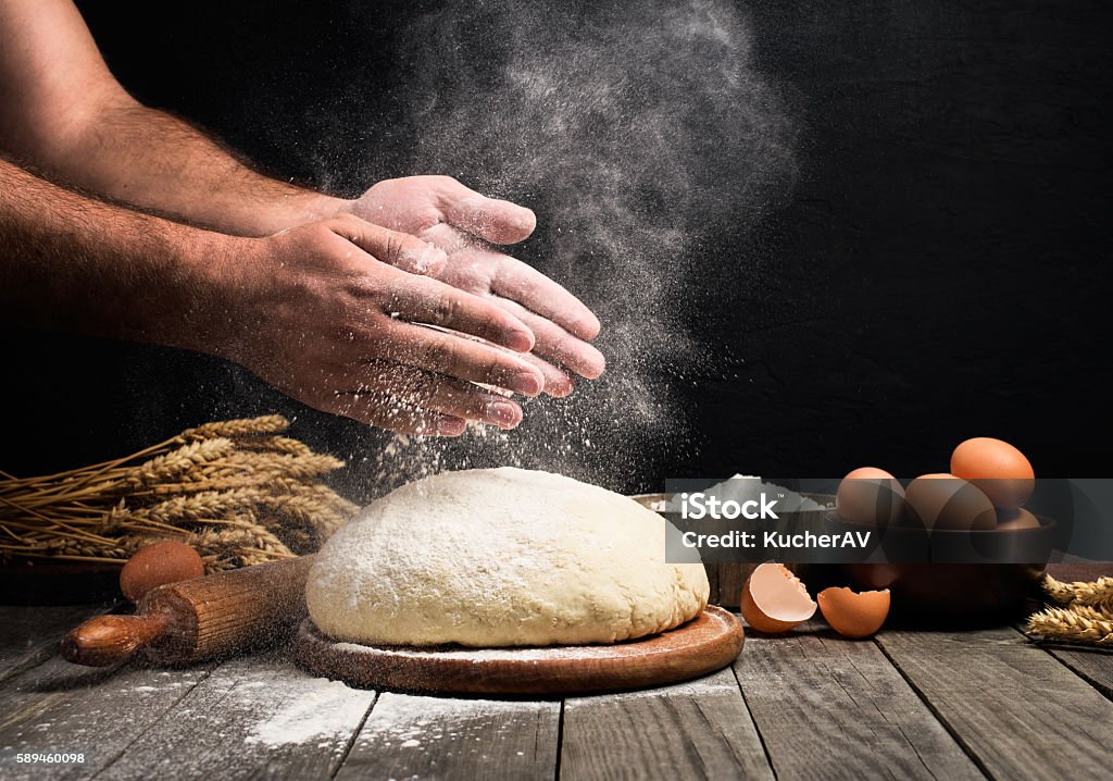 Man Making bread Baker cooking bread. Man slaps flour over the dough. Man Making bread Baking Bread Stock Photo