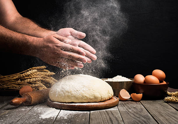 Man Making bread Baker cooking bread. Man slaps flour over the dough. Man Making bread baking bread photos stock pictures, royalty-free photos & images