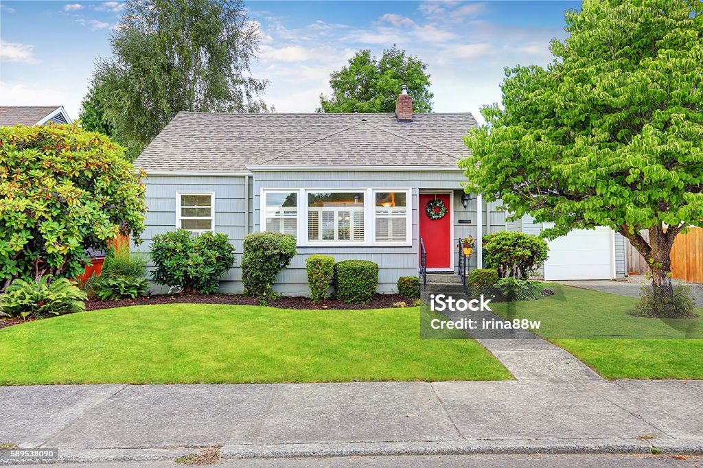 Exterior of small American house with blue paint Exterior of small American house with blue paint and red entrance door. Northwest, USA House Stock Photo