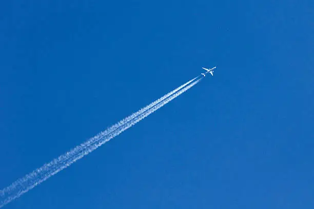 Photo of White airplane trace on blue sky