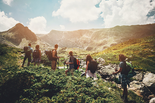 Group of hikers standing on a footpath in the mountain contemplating the scenics.