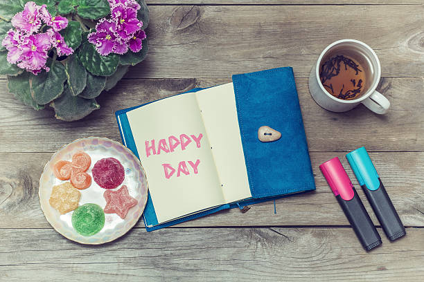 istock Tea with sweets and an inscription in notebook: Happy day 589546360
