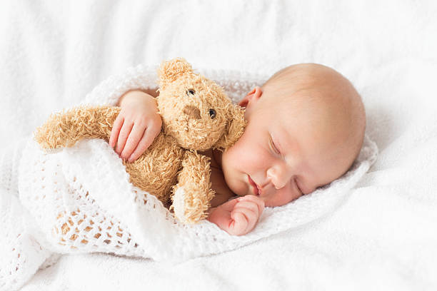 neonato dormire - baby sleeping bedding teddy bear foto e immagini stock