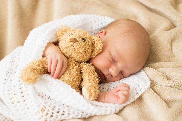 bambino che dorme insieme all'orsacchiotto - baby sleeping bedding teddy bear foto e immagini stock