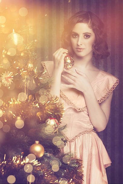 istock young woman decorating christmas tree 589551206