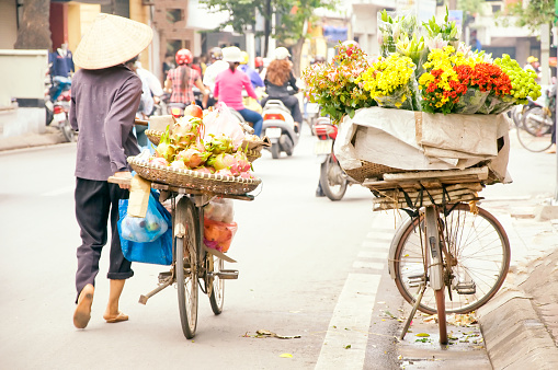 Vietnam florist vendor on bicycle on street in Hanoi.