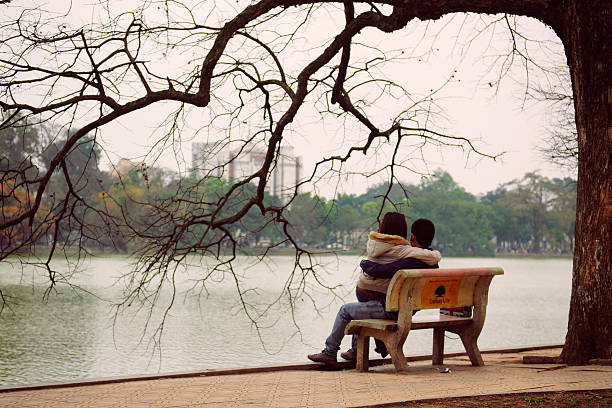 Hanoi, Vietnam - 10 March, 2012: The couple sit on the bench at Hoan Kiem lake