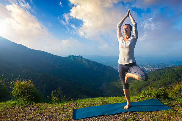 ヨガアサナヴリクシャサナの木のポーズ屋外の山の女性 - tree pose ストックフォトと画像