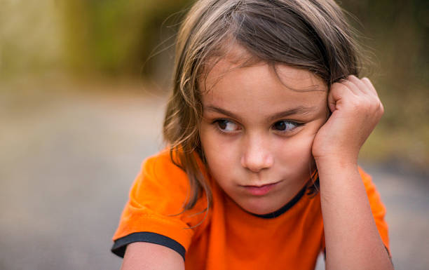 portrait d’une petite fille inquiète pensant avec un ex facial négatif - child blank expression pensive focus on foreground photos et images de collection