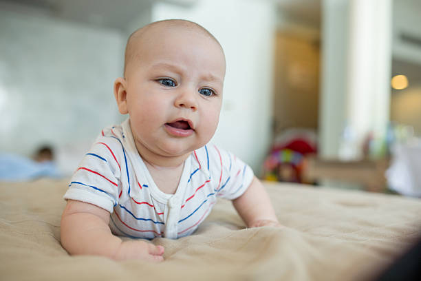 istock Baby with blue eyes lying on the bed. 589556686