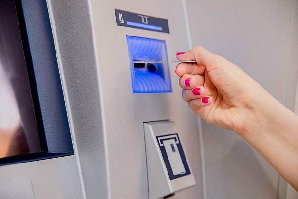 Woman's hand inserting plastic card Visa into the ATM