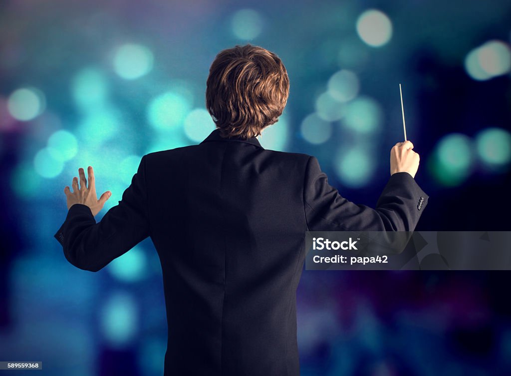 The conductor of the orchestra. Man conducting an orchestra Musical Conductor Stock Photo