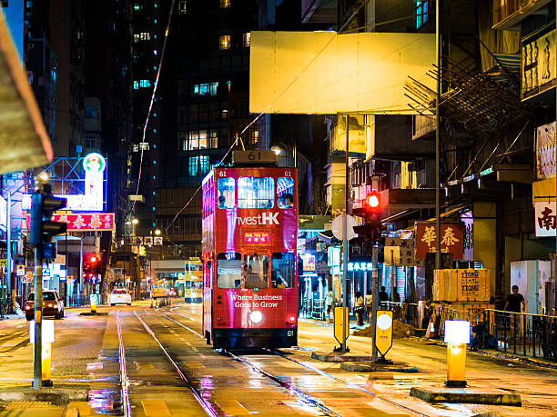 Hong Kong, Hong Kong - September 2, 2013: A double-decker tram passing through the vibrant streets of Hong Kong at night.