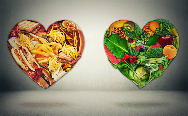 Diet choice dilemma and heart health concept Diet choice dilemma and heart health concept. Two hearts one shaped of green vegetables fruit and alternative one made of  fatty junk high calorie food. Heart disease and food medical health care metabolic syndrome stock pictures, royalty-free photos & images