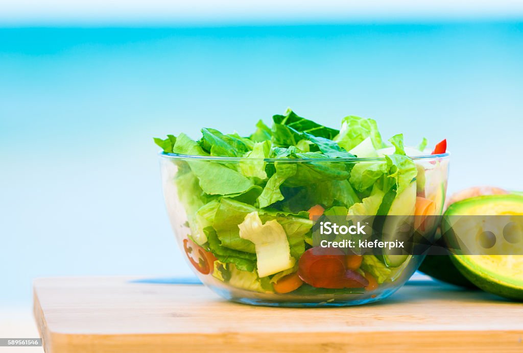 Bowl of salad Bowl of vegetable salad against beach background. Antioxidant Stock Photo