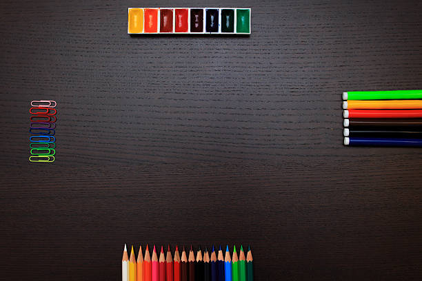 istock Color pencils, paints, clips and markers on dark background with 589562334