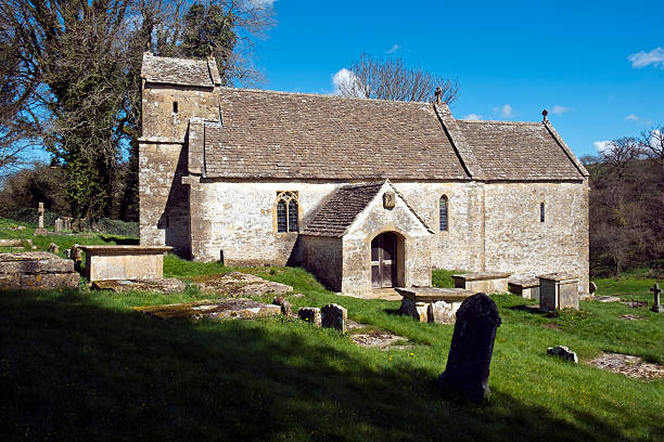Spring sunshine on the picturesque old church at Duntisbourne Rouse in the Cotswolds, Gloucestershire, UK