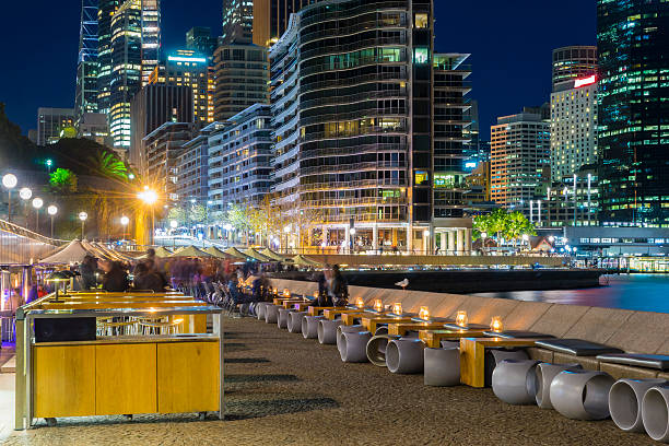 Cafe with people and illuminated buildings at night