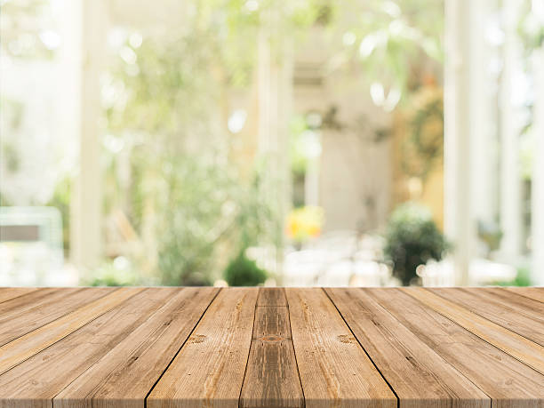 Wooden board empty table blur in coffee shop.