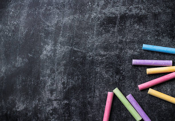 istock Pieces of school chalk on old black chalkboard 589565826