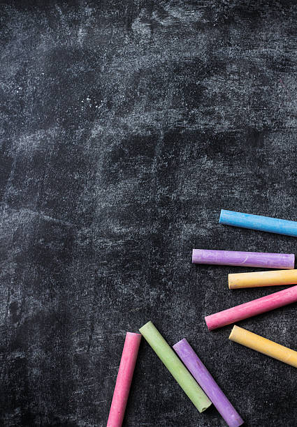istock Pieces of school chalk on old black chalkboard 589566230