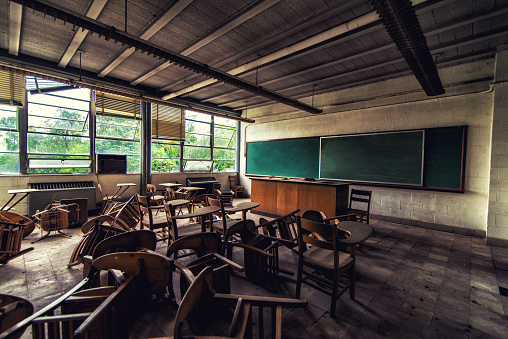 A science classroom at an abandoned college filled with desks.