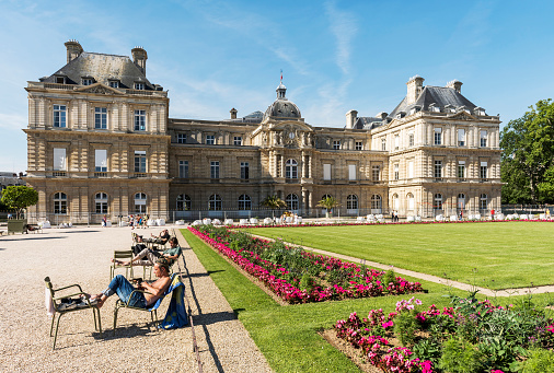 Paris, France - July 7, 2016: People relaxing near French Senato in the largest public park of Paris - Luxembourg Gardens.