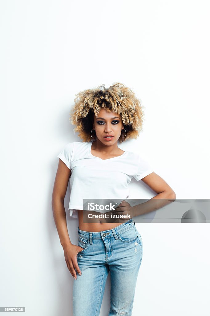 Portrait of afro american young woman Portrait of sensual afro american young woman wearing denim trausers, looking at camera. Fashion Model Stock Photo