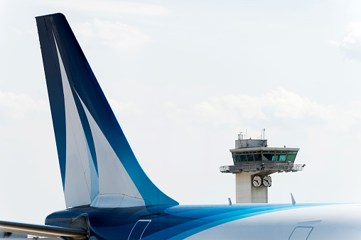 Paris, France - July 8, 2016: Detail of passenger aircraft by the Corsair Airlines and flight tower in Orly - Paris international airport, France.