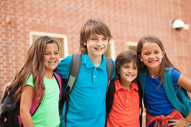 istock Elementary-age children, friends on school campus going back to school. 589574968