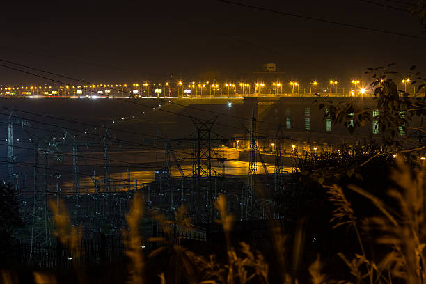 гидроэлектроэнергия освещенных ночных огней. - flowing river water dam стоковые фото и изображения