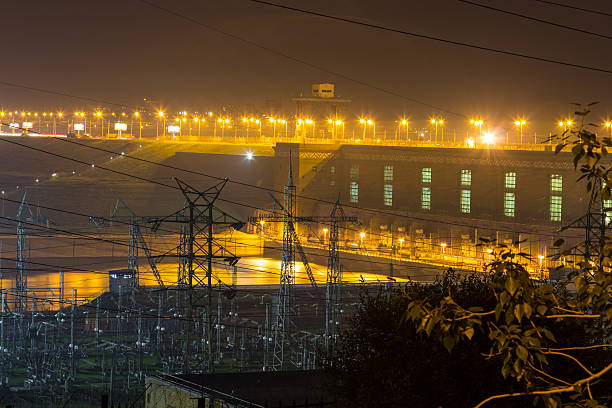 гидроэлектроэнергия освещенных ночных огней. - flowing river water dam стоковые фото и изображения