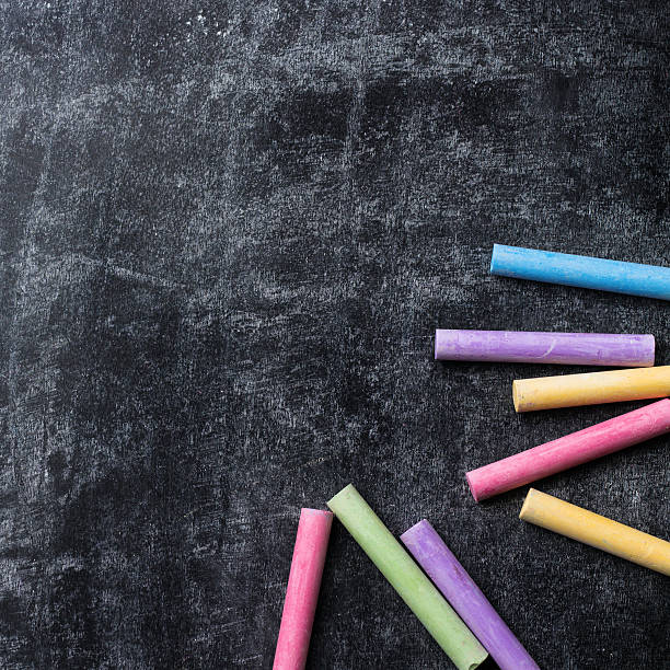 istock Pieces of school chalk on old black chalkboard 589577634