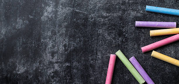 istock Pieces of school chalk on old black chalkboard 589577912