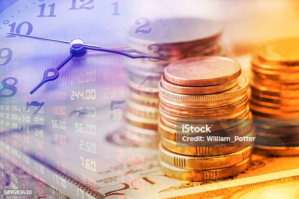 Stack Of Coins And Clock Hands Stock Photo - Download Image Now - Text, Long, Arrival