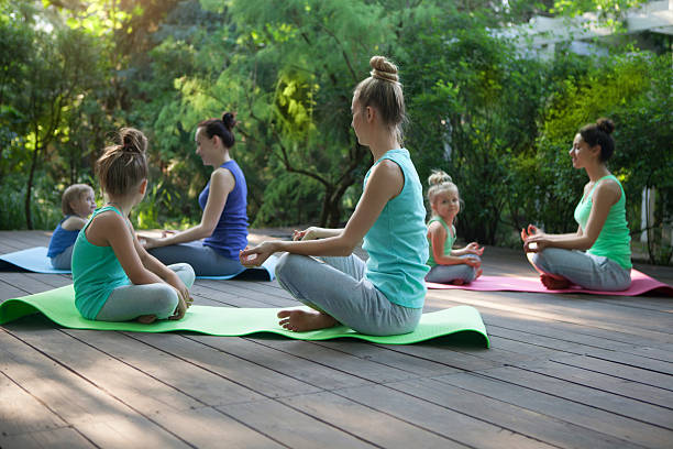 grupo de mães e filhas fazendo exercício praticando yoga ou - gymnastics the splits teenage girls stretching - fotografias e filmes do acervo