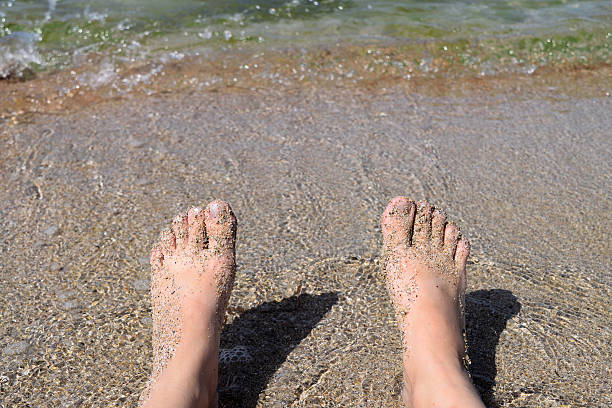 donna seduta sulla spiaggia  - sole of foot human foot women humor foto e immagini stock