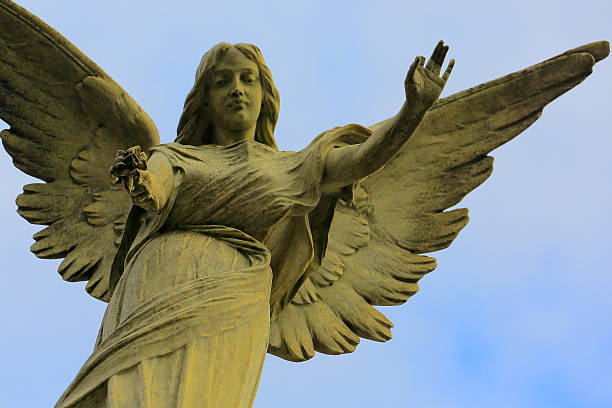 belle madonna angel offrant fleur, ciel bleu, cimetière de recoleta - new life death cemetery flower photos et images de collection